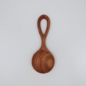 A small, easy-to-hold wooden spoon, perfectly sized for little hands to use in nature play, stirring, and scooping.