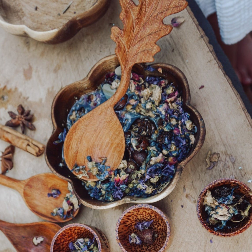 A handcrafted wooden spoon featuring a carved leaf cutout on the handle, ideal for bringing a forest-inspired feel to children’s outdoor play.