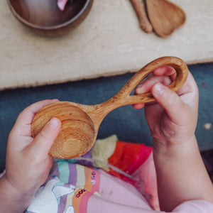 A small, easy-to-hold wooden spoon, perfectly sized for little hands to use in nature play, stirring, and scooping. Tuckered Out